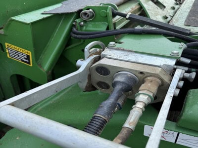 Close-up of hydraulic system and attachment points on John Deere 1293 tractor.
