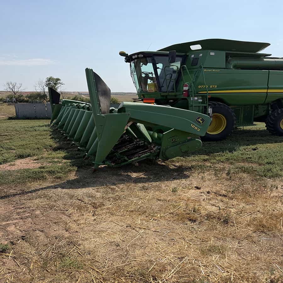 2001 John Deere 1293 combine harvester with green body and large header attachment.