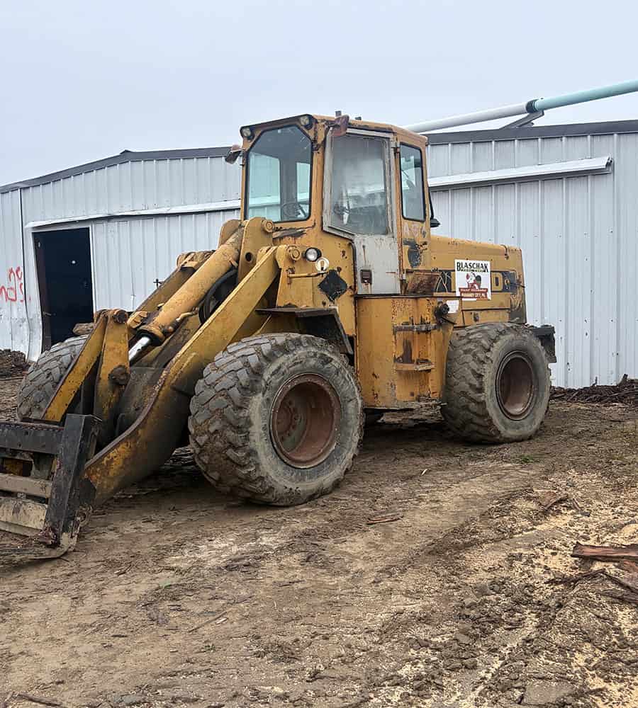unnamed 2 Yellow Ford A64 wheel loader with enclosed cab and large tires on dirt ground.