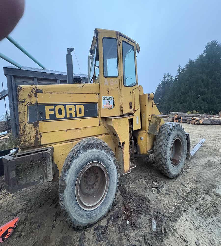 unnamed 5 Yellow Ford A64 wheel loader with enclosed cab and large tires on dirt surface.