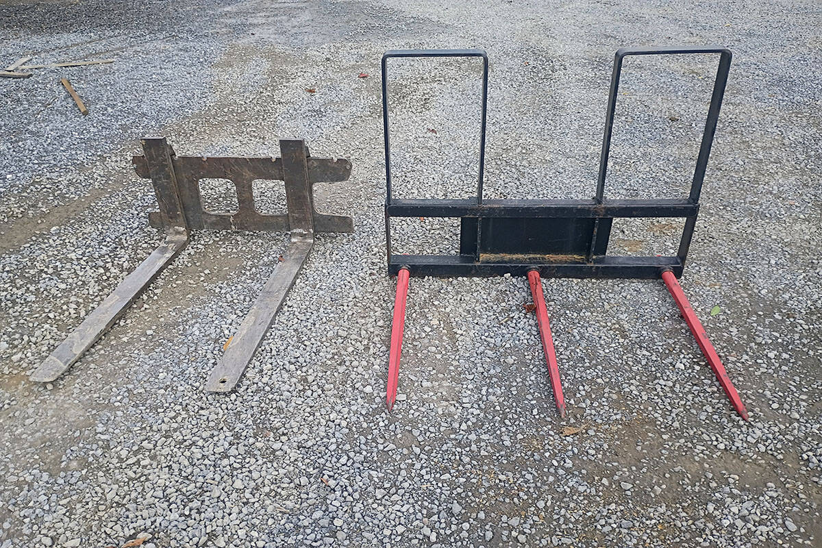 Heavy Equipment Attachments for Skid Steer Two skid steer attachments on gravel surface, one rusty and one newer with red forks and black frame.