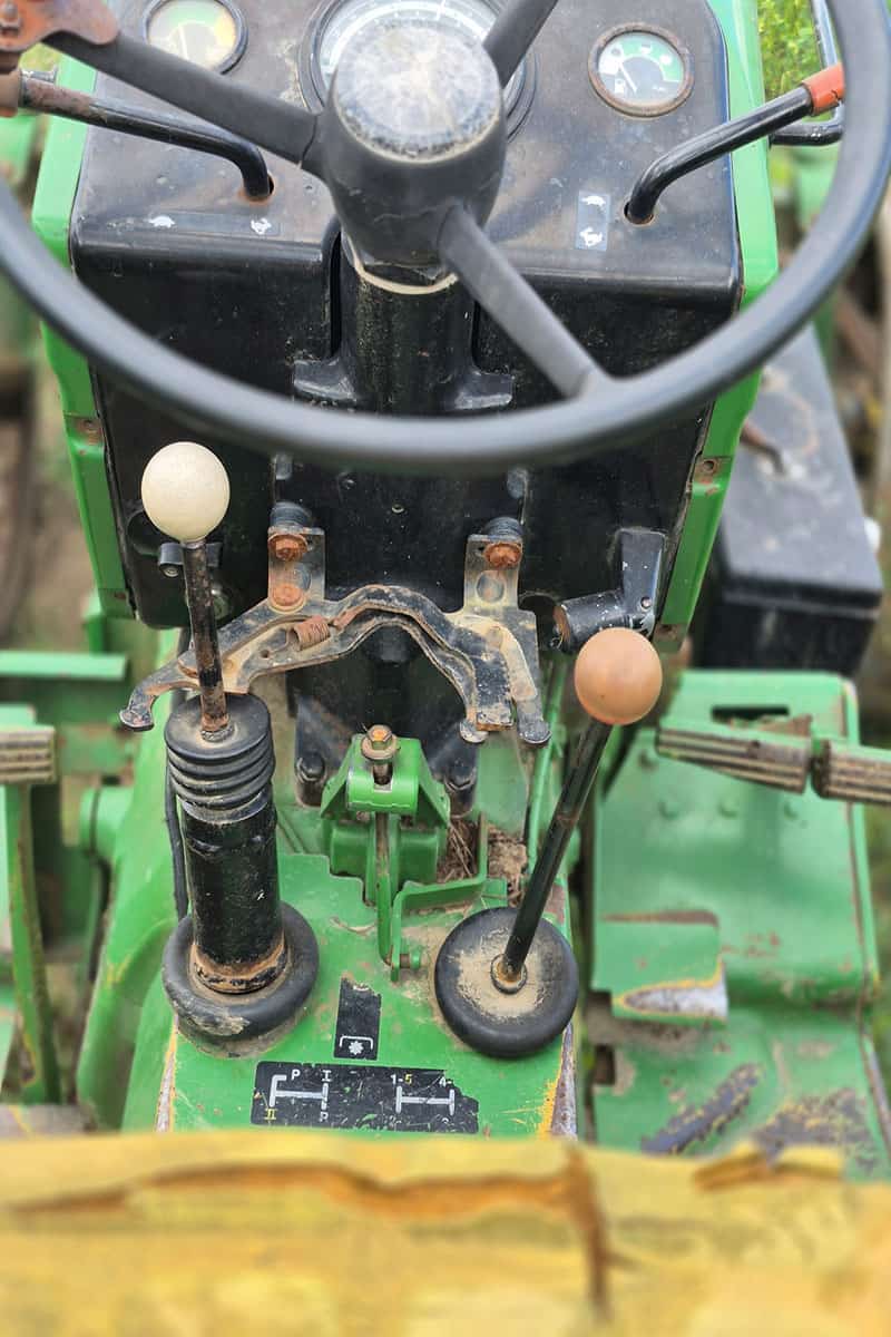 John Deere 420 Tractor Gear Shift and Controls Close-up of John Deere 420 tractor gear shift and control levers with worn surfaces.