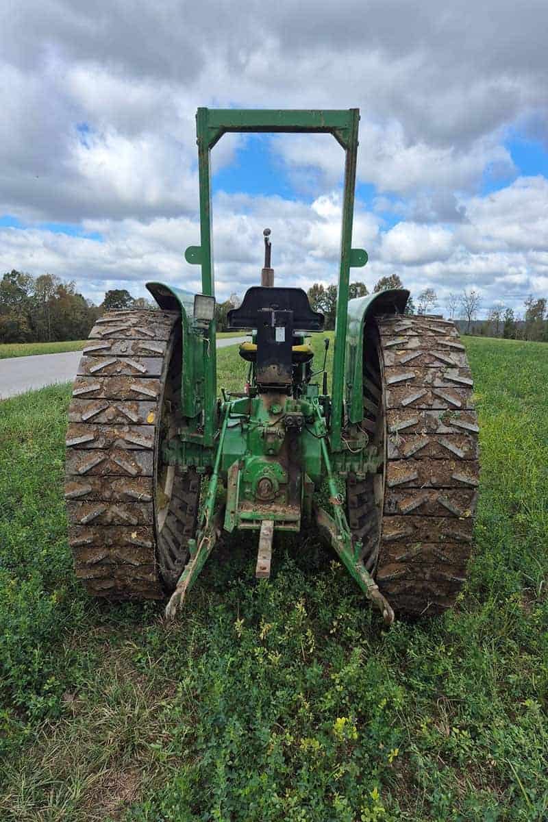 John Deere 5075E Tractor with Rollover Protection John Deere 5075E tractor with large rear tires and rollover protection frame on a grassy field.