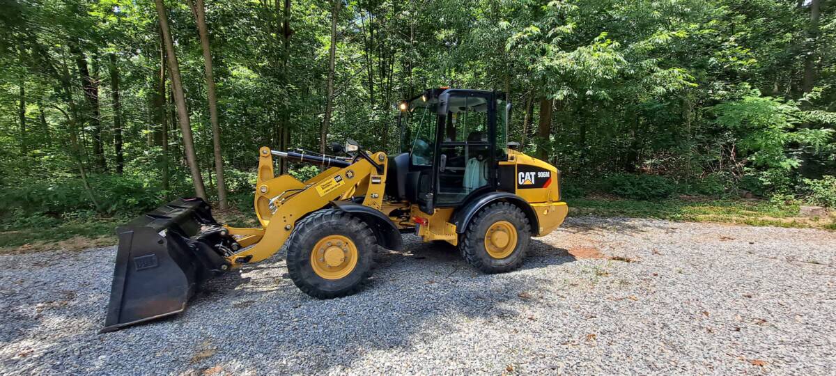 2018 CAT 906M compact wheel loader with bucket attachment on gravel surface.