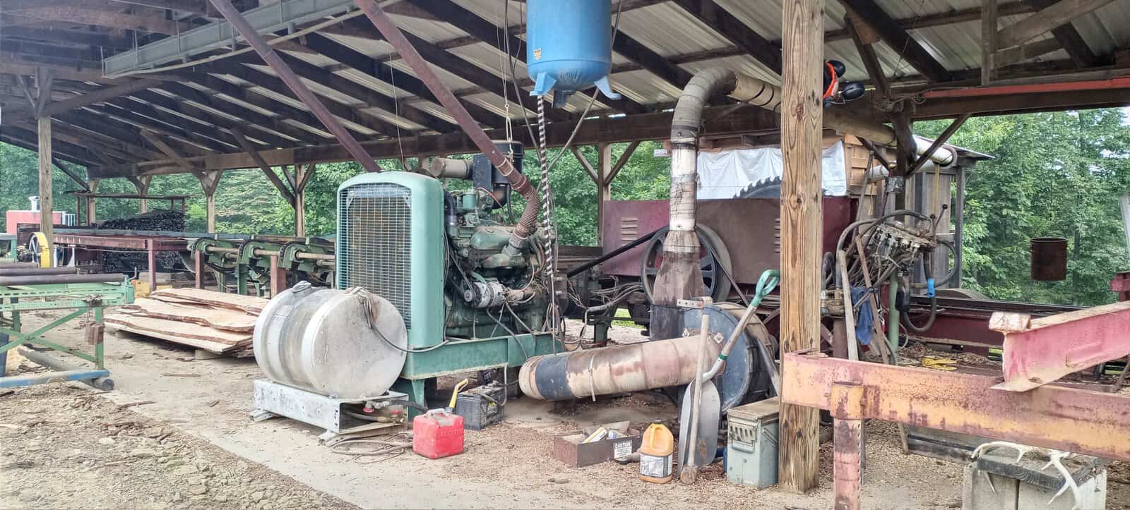 Meadows No. 1 Circular Sawmill engine system Circular sawmill with vintage green engine and exposed belts under a covered outdoor shed.