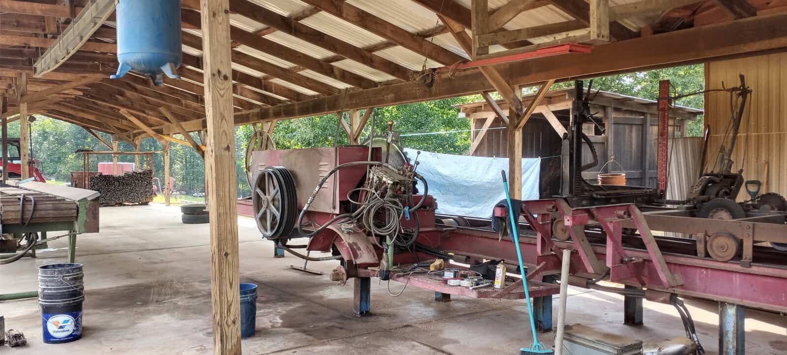 Meadows No. 1 Circular Sawmill — old portable mill Old circular sawmill in a covered outdoor workshop with timber framing and equipment.