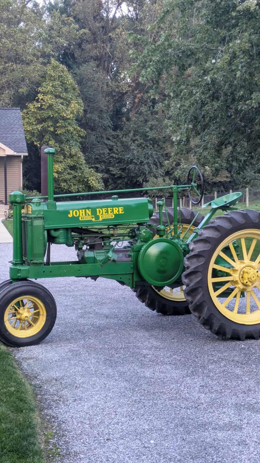 4455 (1) 1938 John Deere A tractor with green body and yellow wheels on a gravel driveway.