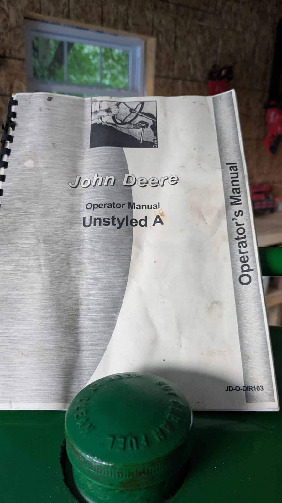 4459 (1) John Deere Unstyled A operator manual with a green Deere cap in front.