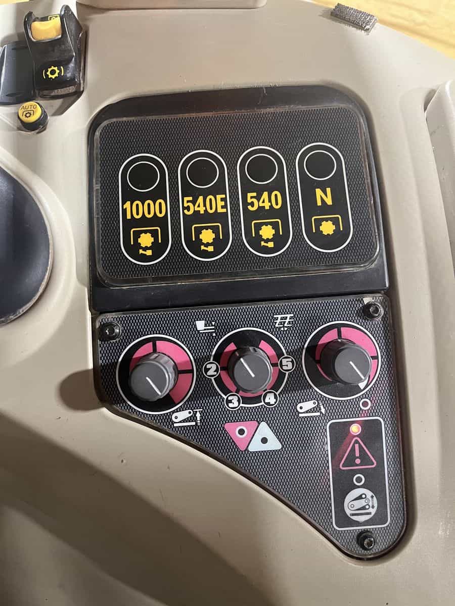 Agricultural Equipment Control Panel with Engine Settings Close-up of tractor control panel showing engine power settings and warning indicators.