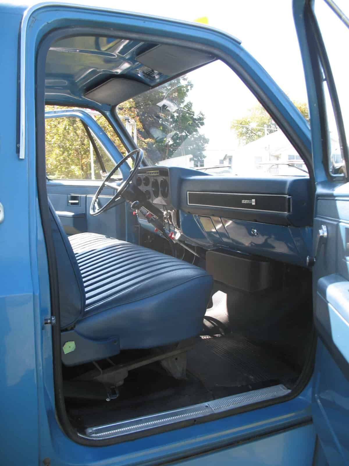 1985 GMC C7000 Cab Interior View Blue 1985 GMC C7000 grain truck interior with bench seat and dashboard.