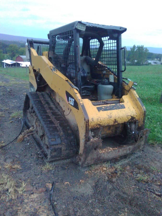 2008 CAT 259B compact track loader with enclosed cab and rubber tracks on a dirt surface.