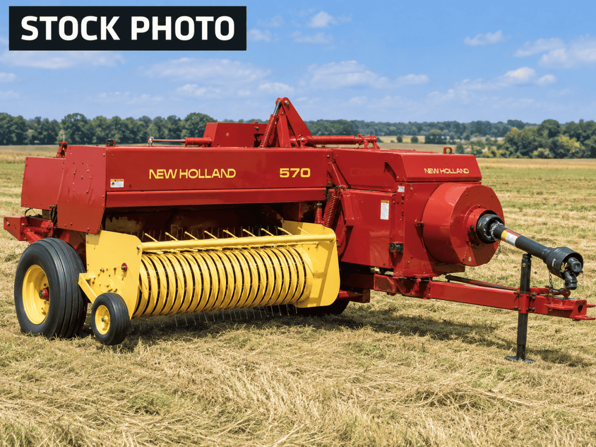 New Holland 570 hay rake with yellow tines and red body in a field.