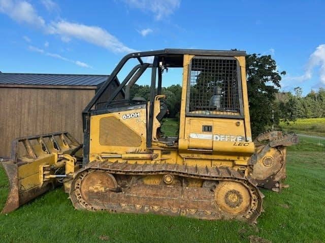 RAW_JD 650H 3 (1) John Deere 650H tracked bulldozer with blade attachment on grassy field.