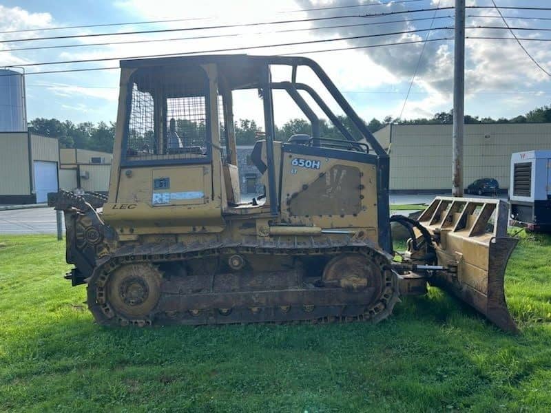 RAW_JD 650H 4 John Deere 650H tracked skid steer loader with front blade attachment on grassy lot.