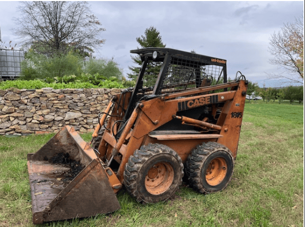 Case 1845 Skid Steer Loader for Sale Case 1845 skid steer loader with bucket attachment on grassy field.