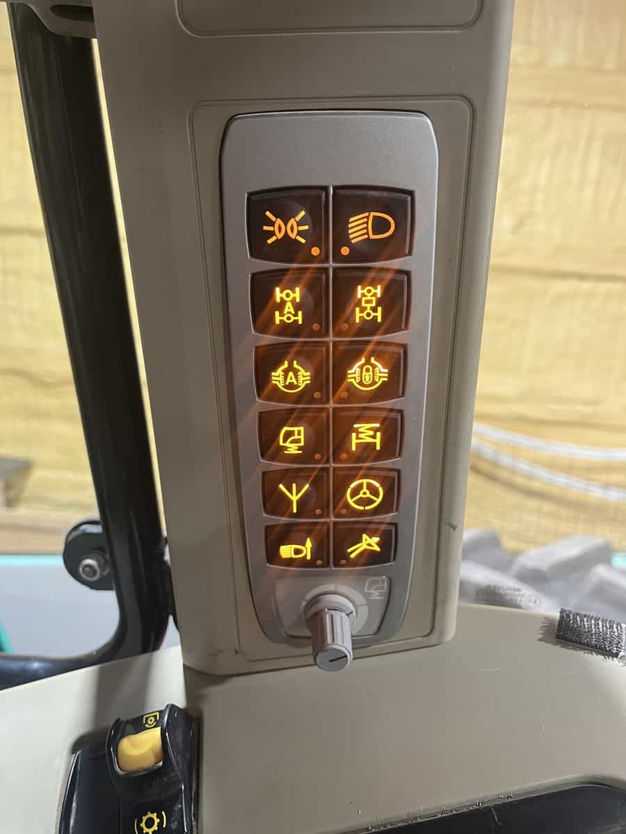 Agricultural Equipment Control Panel Close-up of illuminated control panel with various symbols in a tractor cab.