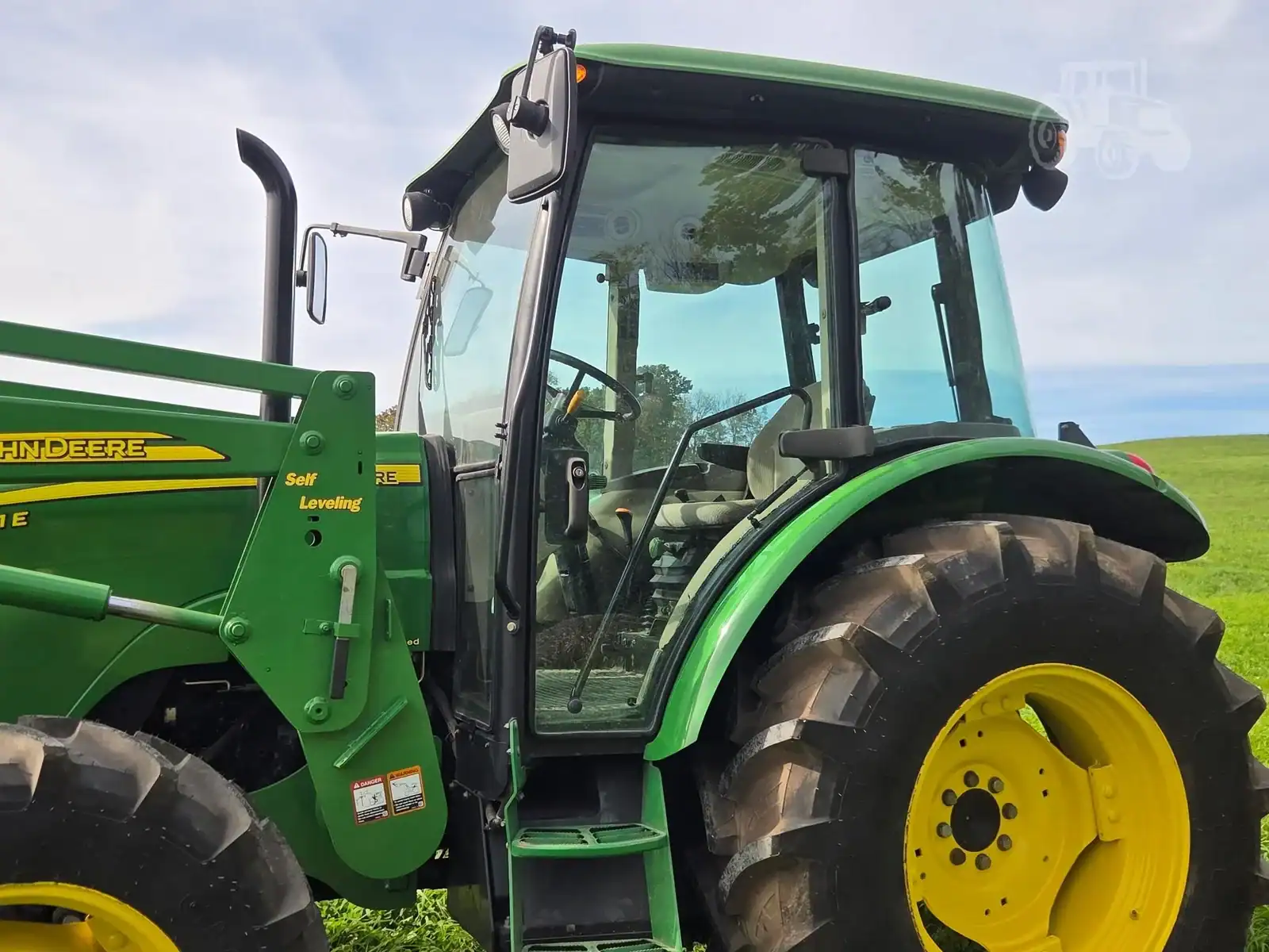 img (1) 2010 John Deere 5101E tractor with enclosed cab and large rear tires.