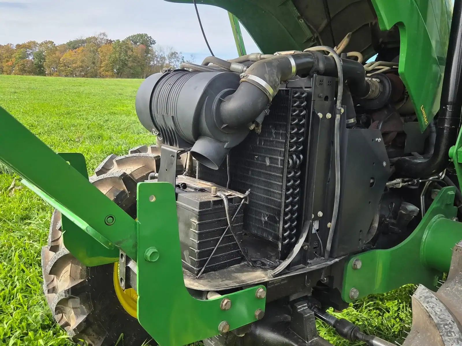 img (12) Close-up of 2010 John Deere 5101E tractor engine and radiator in a field.