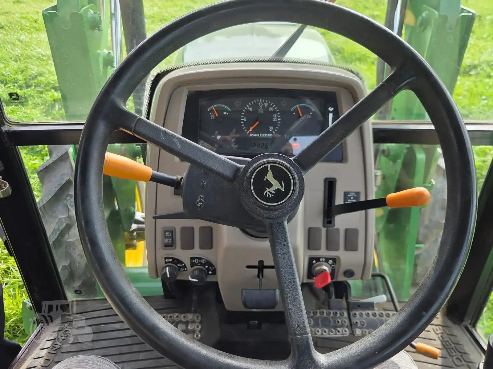 img (21) Interior view of a 2010 John Deere 5101E tractor dashboard and steering wheel.