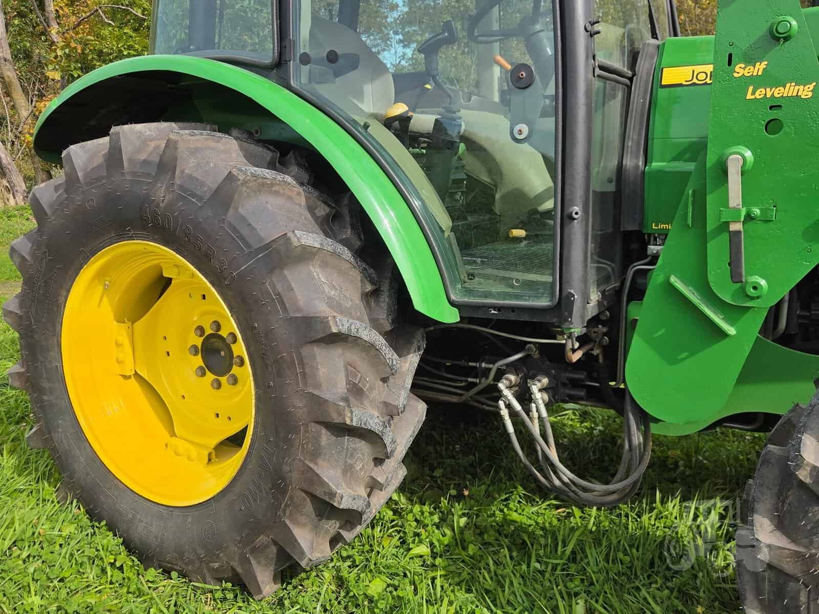 2010 John Deere 5101E Tractor Tire Detail Close-up of 2010 John Deere 5101E tractor rear tire with green body and yellow rim.