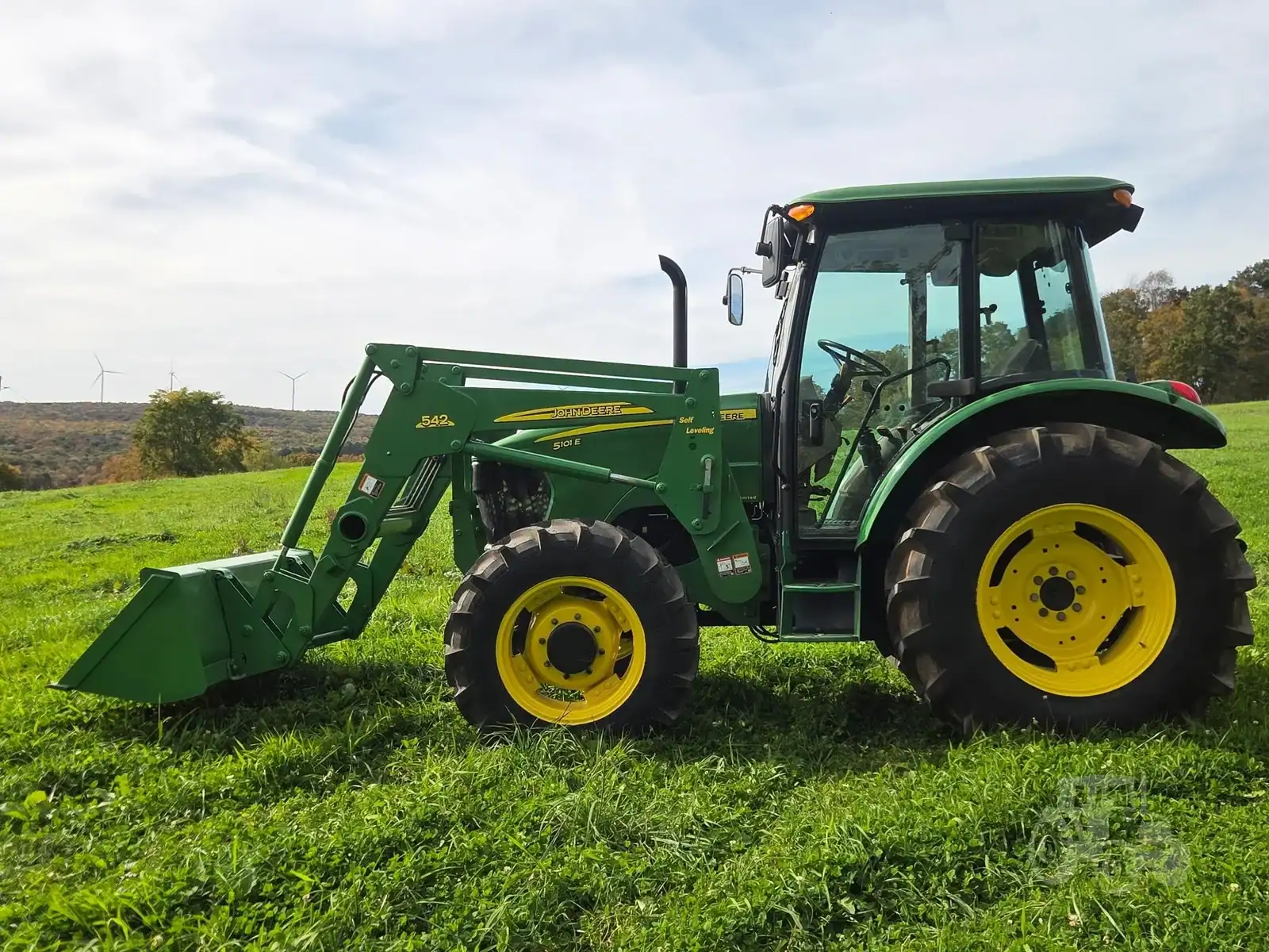 2010 John Deere 5101E Tractor with Loader 2010 John Deere 5101E compact tractor with front loader and enclosed cab on grassy field.
