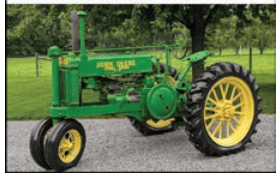 1938 John Deere A Tractor in Green 1938 John Deere A vintage tractor with yellow wheels and green body on a farm.