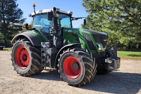 Green and black John Deere tractor with red wheels, outdoor setting, no visible year or model.