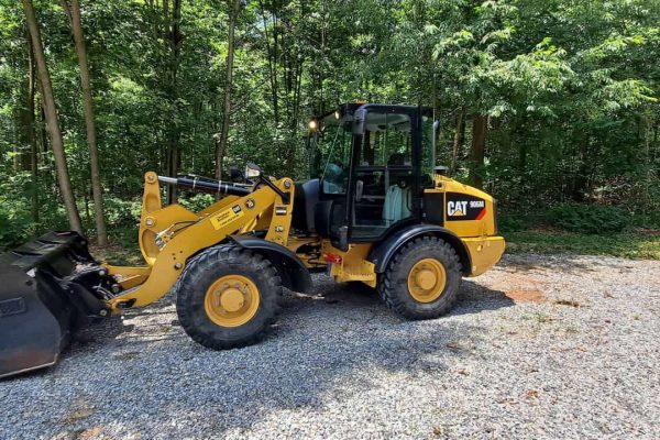 2018 CAT 906M compact wheel loader with bucket attachment on gravel surface.