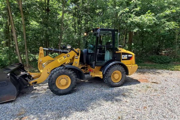 2018 CAT 906M compact wheel loader with bucket attachment on gravel surface.