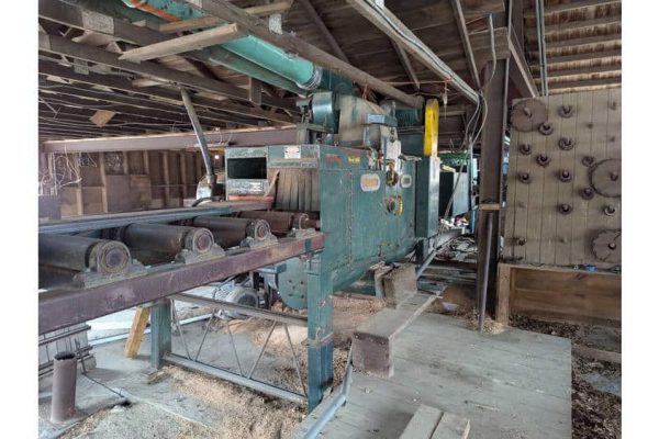 High-capacity industrial woodworking machine in a rustic workshop setting.