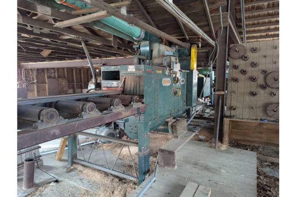 High-capacity industrial woodworking machine in a rustic workshop setting.