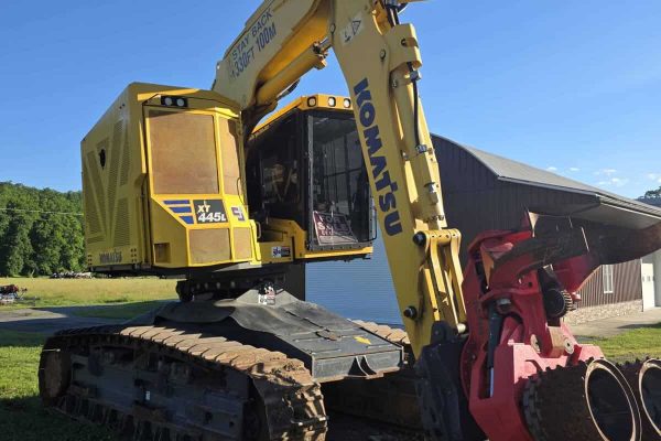 Komatsu PC45MR-5 mini excavator with yellow body and black tracks, working outdoors.