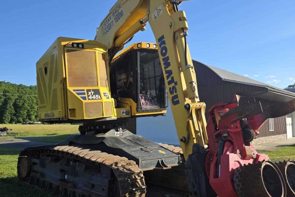 Komatsu PC45MR-5 mini excavator with yellow body and black tracks, working outdoors.