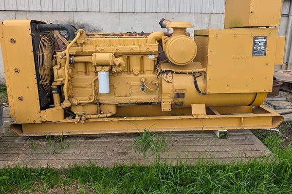 Yellow Caterpillar 155 kW generator with control panel and cooling system.