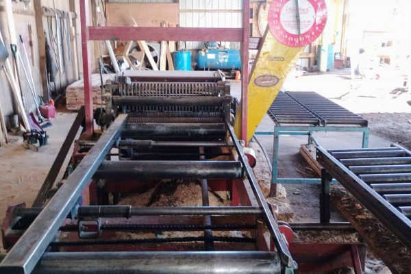 Industrial metal slitter machine in a warehouse setting, no visible year, make, or model.