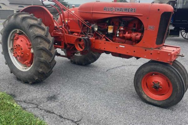 Red Allis-Chalmers WD vintage tractor with large rear tires and open cab.