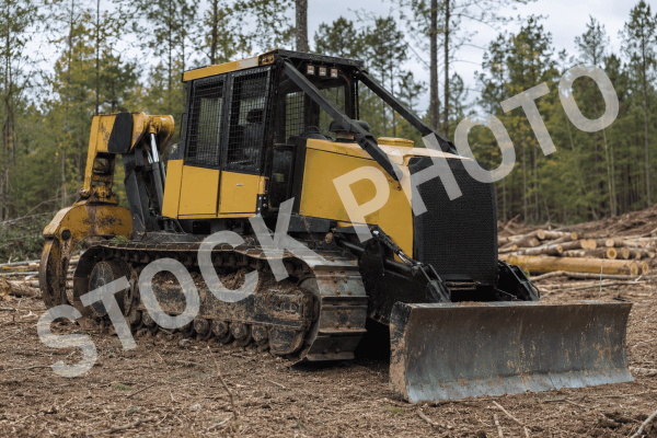 KMC 1000AG track skidder with enclosed cab and blade attachment in a forest clearing.
