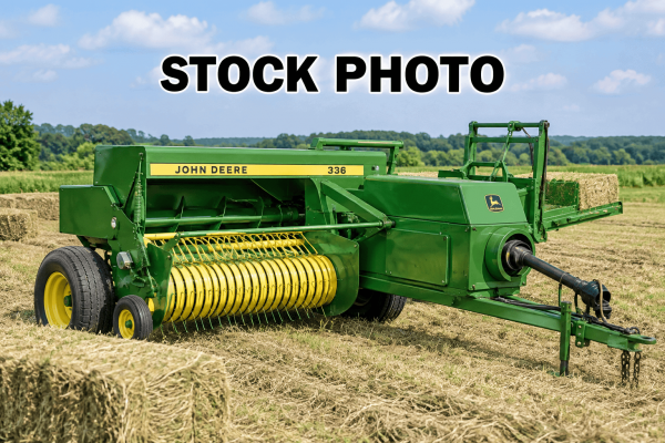 John Deere 336 hay baler in a field with hay bales.