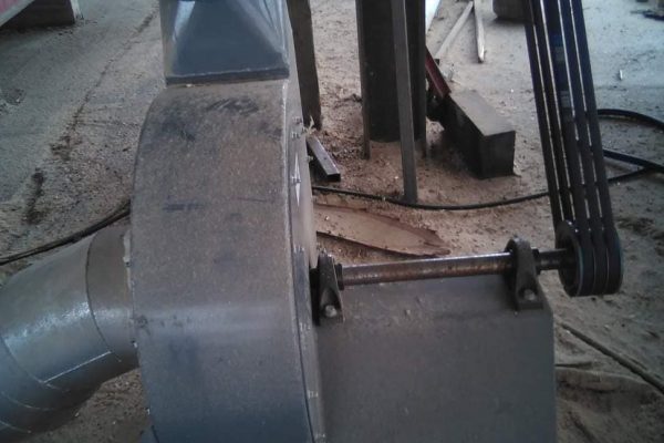 Industrial dust collection system with ductwork and blower, used in manufacturing facilities.
