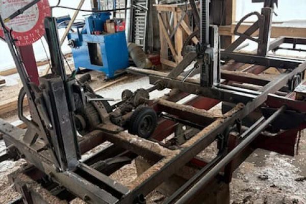 Heavy-duty metal frame with various mechanical components in a workshop setting.