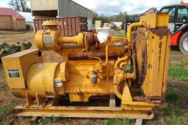 Caterpillar D334 diesel engine with radiator and cooling fan, yellow color, outdoor setting.