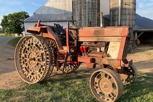 Farmall 300 tractor with steel wheels and rusted orange paint, vintage farm equipment from the 1950s.