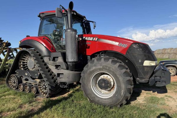 2016 Case IH Magnum 340 tractor with cab and track system on grassy field.