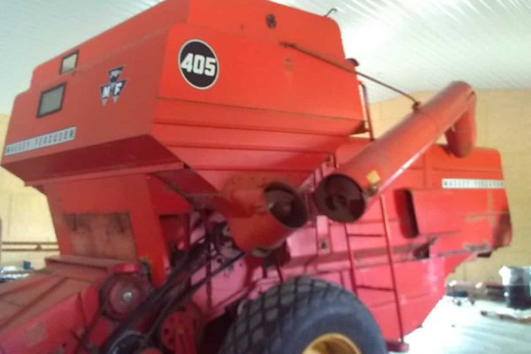 Red Massey Ferguson 405 round baler with large tires and baling chamber.