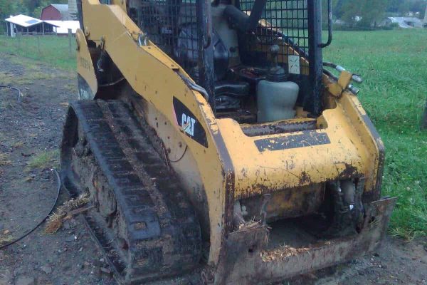 2008 CAT 259B compact track loader with enclosed cab and rubber tracks on a dirt surface.