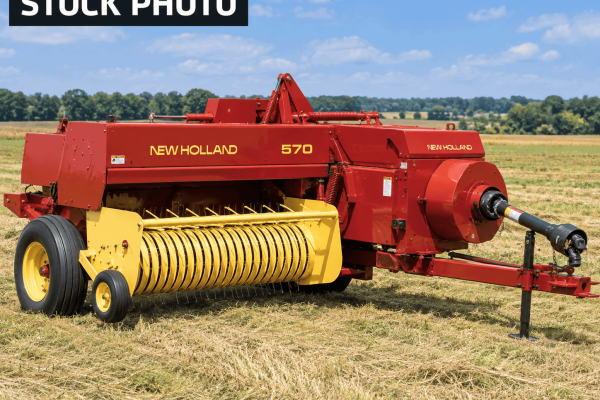 New Holland 570 hay rake with yellow tines and red body in a field.
