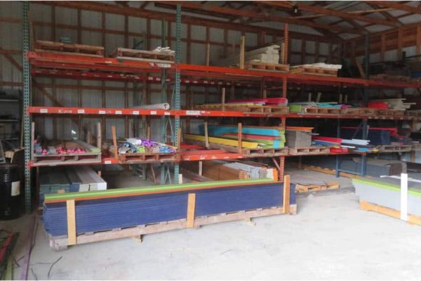 Heavy-duty shelving units with various building materials stored inside a warehouse.