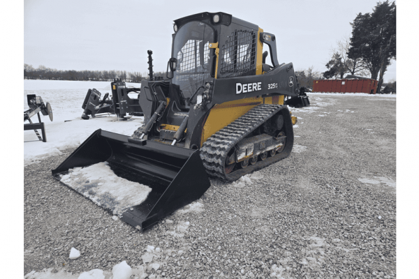 Excavator John Deere 35G compact track loader with bucket attachment on gravel surface in winter.