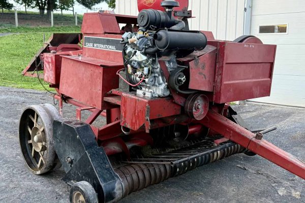 Red Case International forage harvester with engine and feeding mechanism.