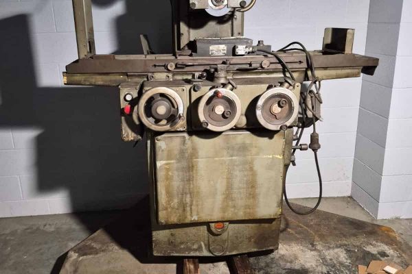 Vintage industrial metalworking machine with control dials and electrical components.